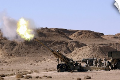 Flame and smoke emerge from the muzzle of an M198 Howitzer
