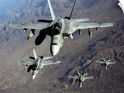 Four U.S. Navy F/A 18 Hornet aircraft fly over mountains in Afghanistan