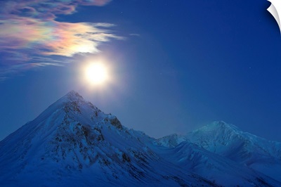 Full moon with rainbow clouds over Ogilvie Mountains, Canada