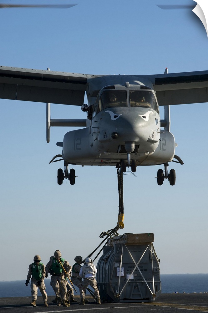 Arabian Gulf, October 9, 2014 - Marines attach the hoist sling of an AV-8B Harrier jet engine container to an MV-22 Osprey...