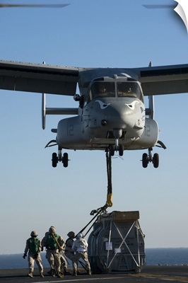 Marines Attach The Hoist Sling Of An AV-8B Harrier Jet Engine Container To MV-22 Osprey