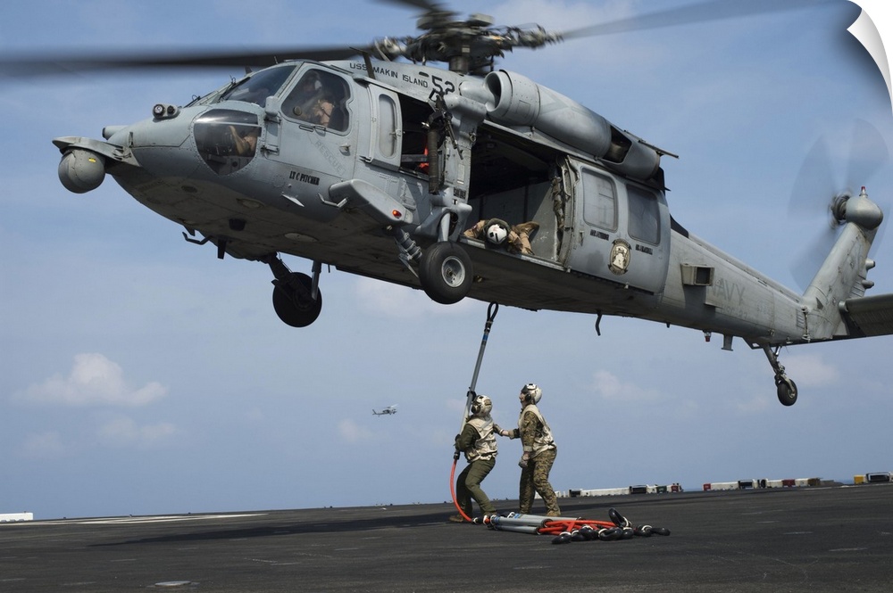 Gulf of Aden, December 9, 2014 - Marines secure a hoist sling to an MH-60S Seahawk helicopter on the flight deck of the am...