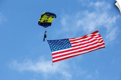 Member of the U.S. Navy Parachute Team flies the American Flag