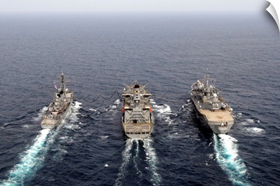 Military ships conduct an underway replenishment in the Pacific Ocean