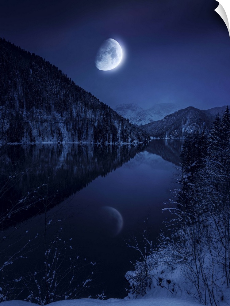 Moon rising over tranquil lake in misty mountains.