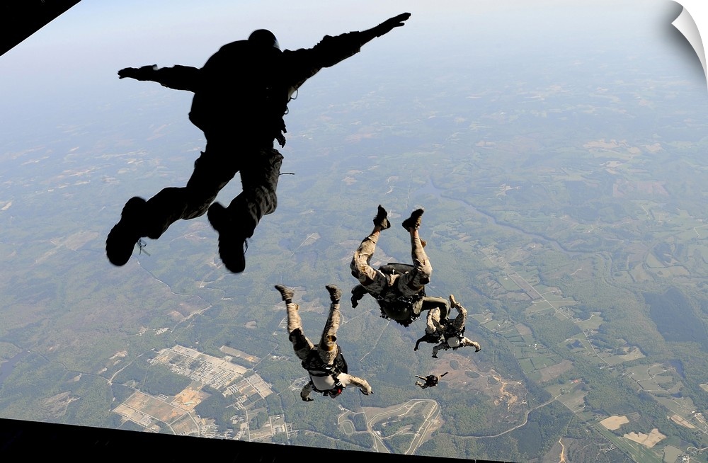 Navy SEALs jump from the ramp of a C-17 Globemaster III over Virginia.