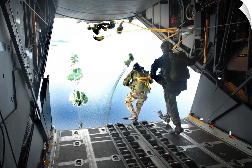 Pararescuemen perform a static-line jump out of a C-130 Hercules.