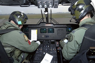 Pilots inside the cockpit of a Royal Air Force Merlin Helicopter at RAF Lyneham