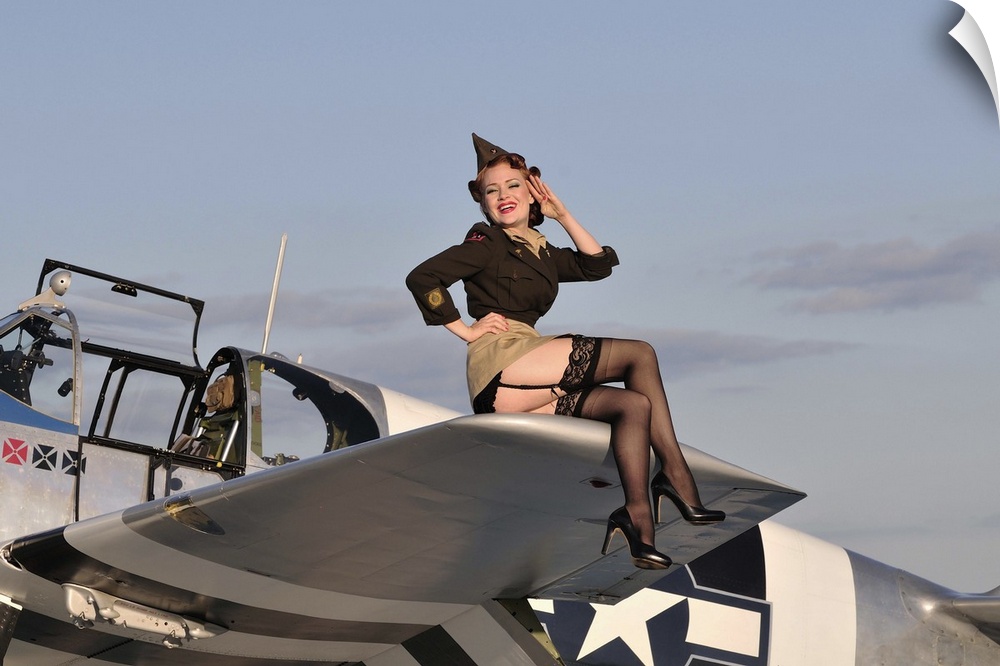 Pin-up girl sitting on the wing of a P-51 Mustang fighter plane.