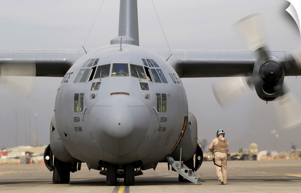 Balad Air Base, Iraq, December 4, 2004 - A loadmaster conducts an engine start up and pre flight inspection on his C-130 H...