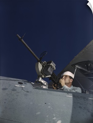 Sailor tries out a .30-caliber machine gun on a Navy plane at Naval Air Base, Texas