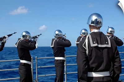 Sailors fire a gun salute during a burialatsea