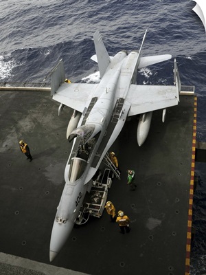 Sailors move an F/A-18C Hornet into the hangar bay