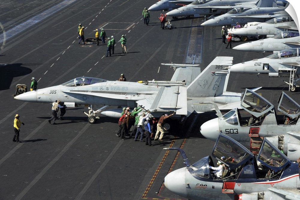 October 30, 2012 - Sailors push an F/A-18C Hornet in preparation for flight operations aboard the Nimitz-class aircraft ca...