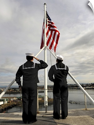 Sailors raise the national ensign aboard USS Abraham Lincoln