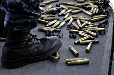 Shell Casings From A 50 Caliber Machine Gun Around The Feet Of A Soldier