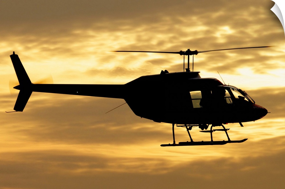 Silhouette of a Bell 206 utility helicopter of Italy's Vigili del Fuoco flying over Italy.