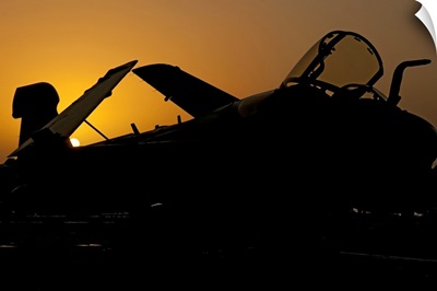 Silhouette of an EA-6B Prowler at sunrise on the flight deck of USS Nimitz