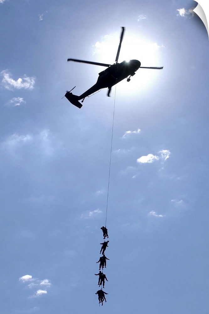 Soldiers and Airmen hang 100 feet above the ground from a UH-60 Blackhawk.