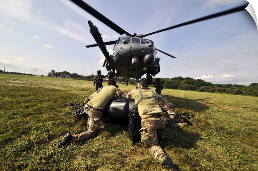 July 24, 2014 - Soldiers mount an inflatable Zodiac boat to the bottom of a HH-60 Pave Hawk helicopter.