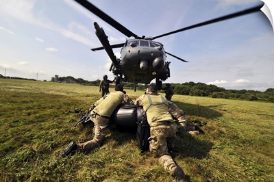 Soldiers Mount An Inflatable Zodiac Boat To The Bottom Of A HH-60 Pave Hawk