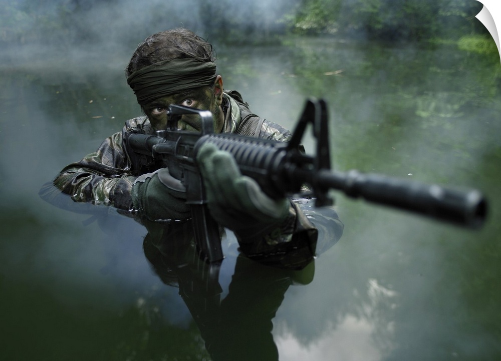 Special operations forces soldier transits the water armed with an assault rifle.