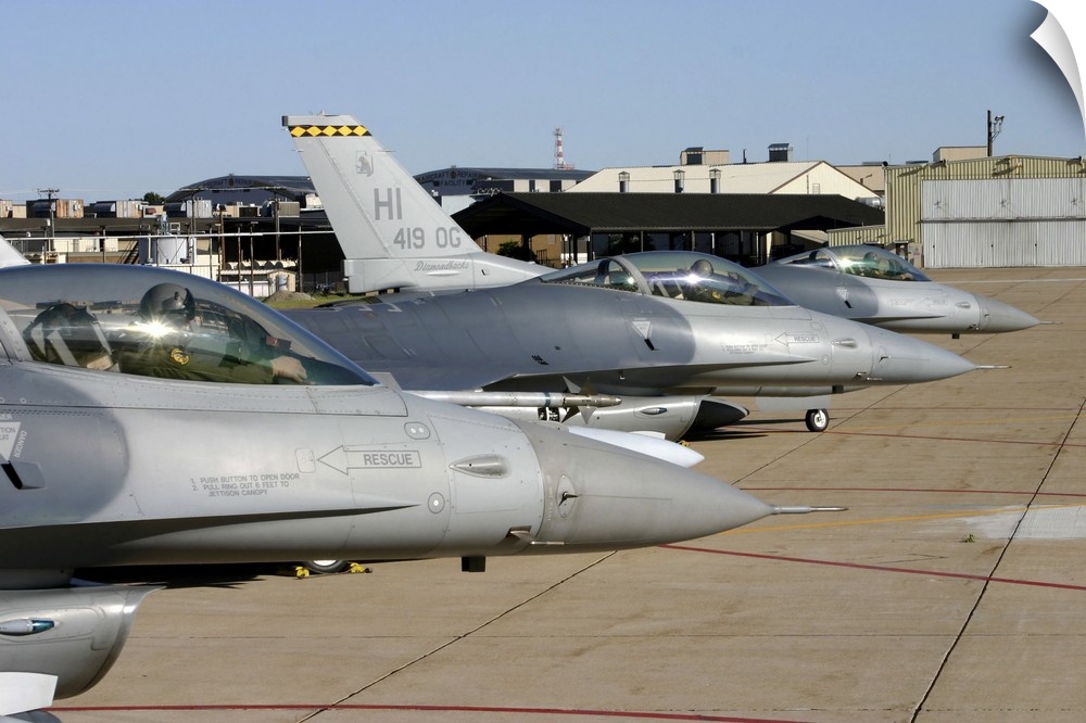 Three F-16 Fighting Falcons prepare to taxi for departure.