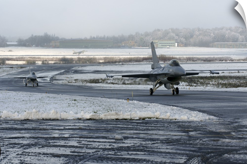 Two F-16 Fighting Falcons taxi down the runway in Florennes, Belgium.