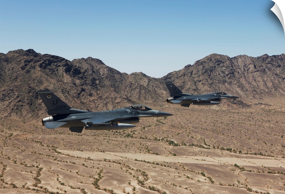 Two F-16's from the 56th Fighter Wing at Luke Air Force Base, Arizona, fly in formation while flying low level over the Ar...