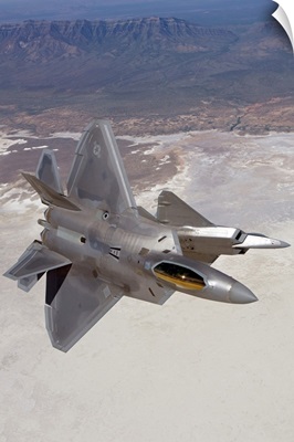 Two F-22 Raptors maneuver while on a training mission over New Mexico