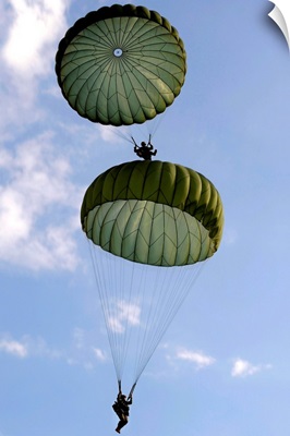 U.S. Army Soldiers parachute down after jumping from a C 130 Hercules
