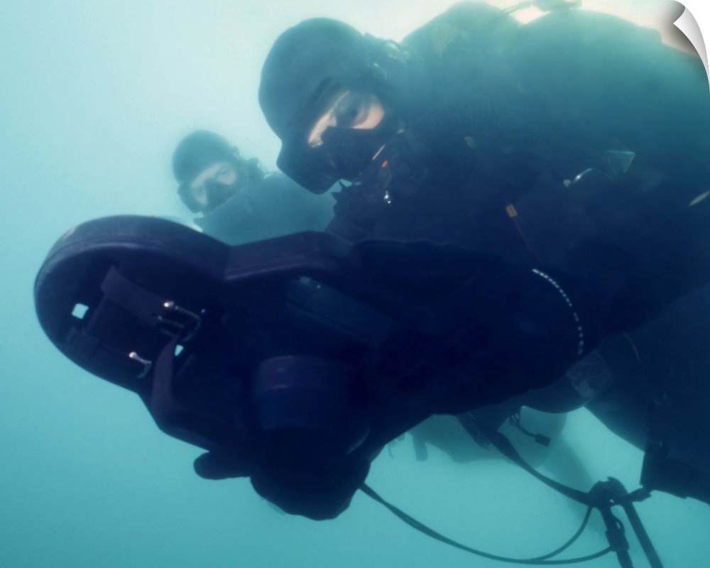 U.S. Navy SEAL combat swimmer pair diving LAR-V pure oxygen rebreather, navigate using a swimmer attack board to reach a t...