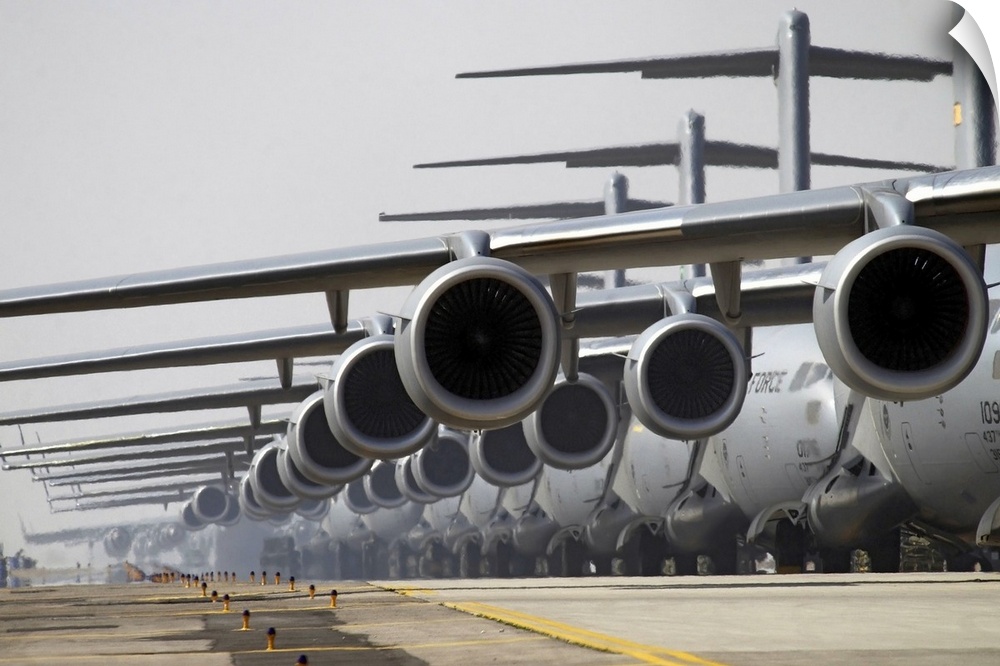 Military phograph looking down a runway at a fleet of C17 US Air Force planes lined up ready for take off.