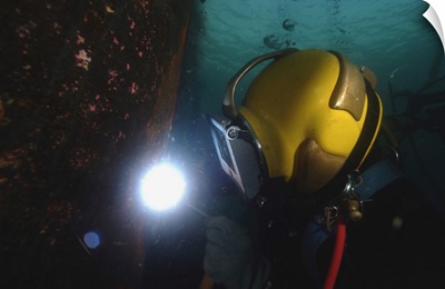 US Navy Diver Welds A Repair Patch On The Submerged Bow Of The USS Ogden