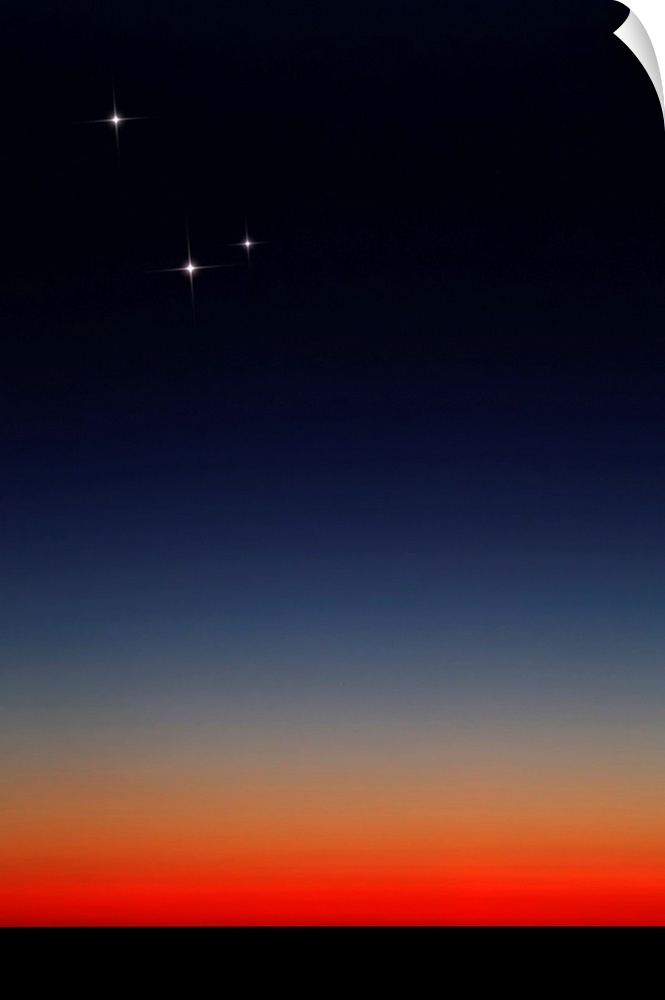 Venus, Mercury and Mars above the glowing horizon at dawn.