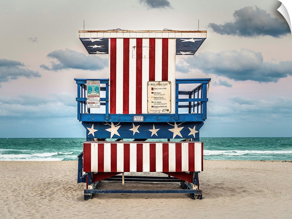 Photograph of a lifeguard tower with an American flag design on the beach.