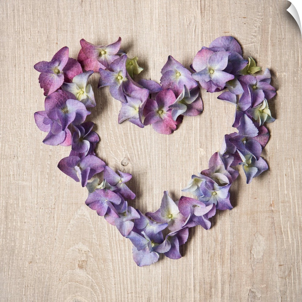 Photograph of purple flowers arranged in the shape of a heart.