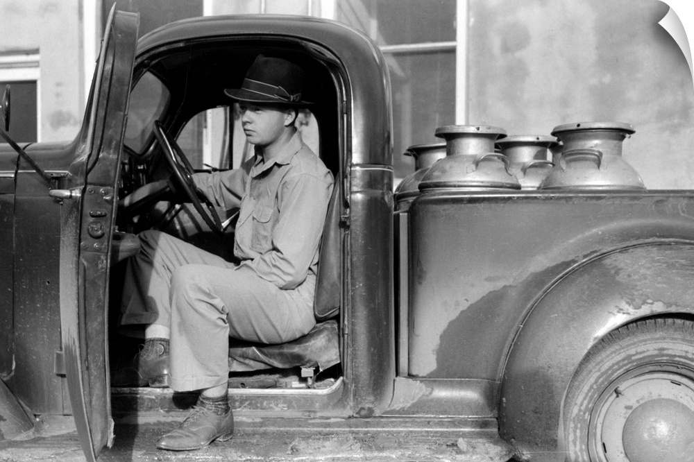 A man waiting to unload milk cans filled with raw milk at a creamery in San Angelo, Texas. Photograph by Russell Lee, Nove...