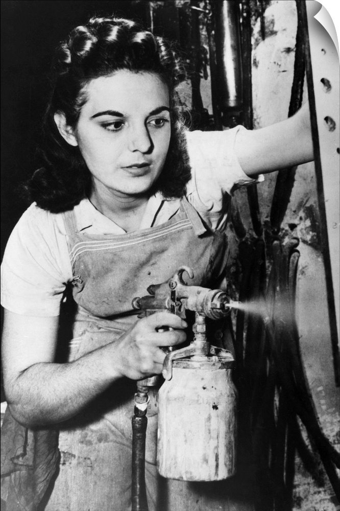 A woman spraying paint on electrical control equipment in a factory in Pittsburgh, Pennsylvania. Photograph, 1942.