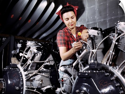 A woman working on an airplane motor at the North American Aviation plant, CA, 1942
