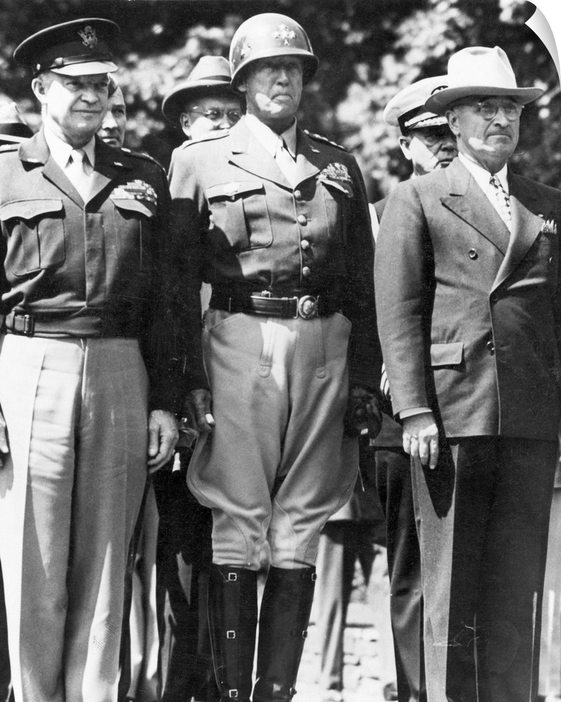 General Dwight D. Eisenhower, General George S. Patton, and President Harry S. Truman watching as the American flag is rai...