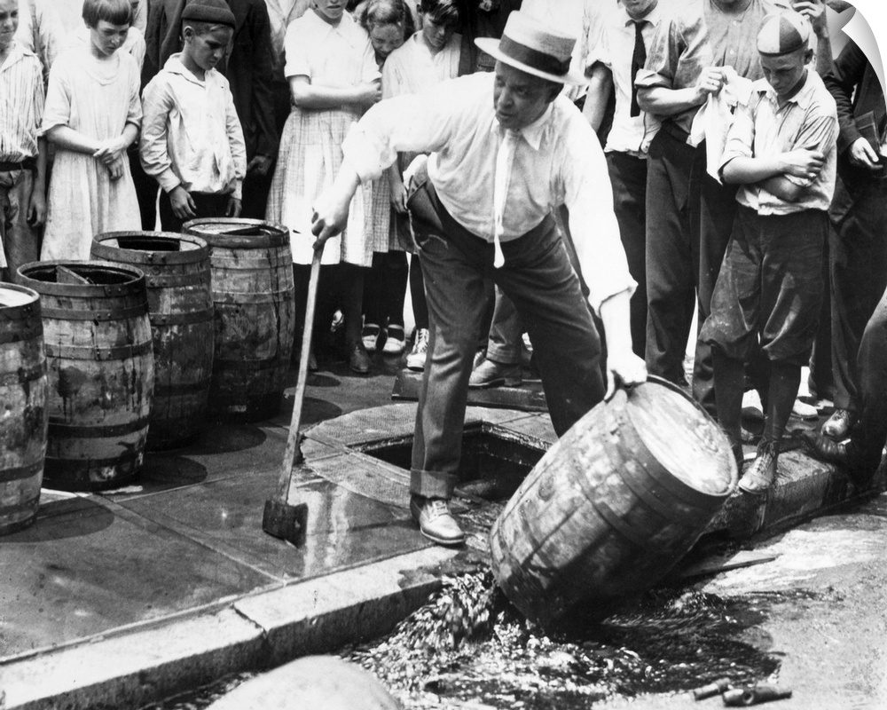 An American official dumping kegs of bootleg liquor into the sewer during Prohibition. Photograph, c1925.