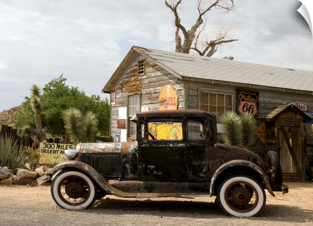 An old rusted automobile in front of the Hackberry General Store along Route 66 in Hackberry, Arizona. Photograph by Carol...