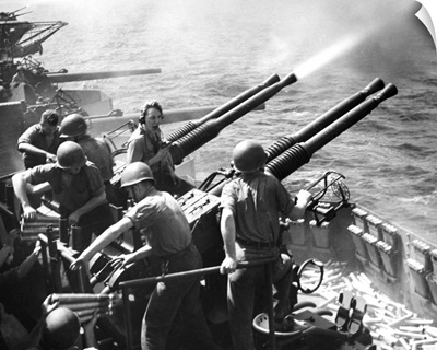 Crew members on board a U.S. Navy aircraft carrier fire anti-aircraft guns, 1943