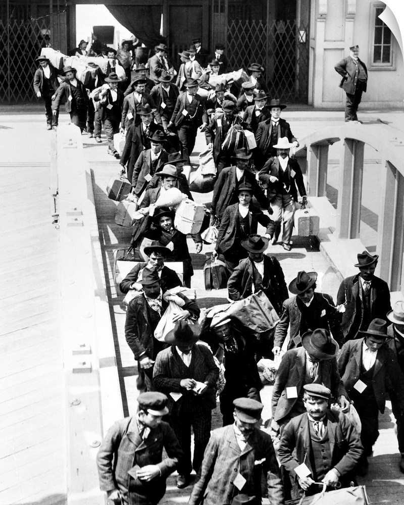 Immigrants arriving at Ellis Island with their belongings. Photograph, c1910.