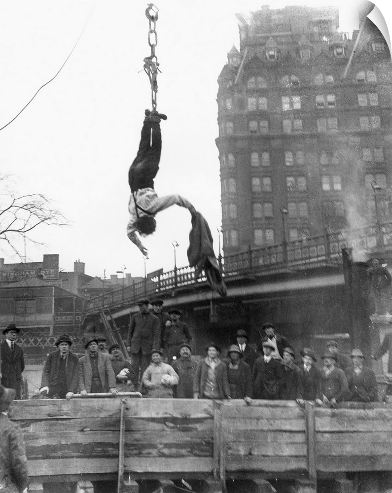 American magician. Houdini escaping from his straitjacket while suspended during a midair stunt in 1916.