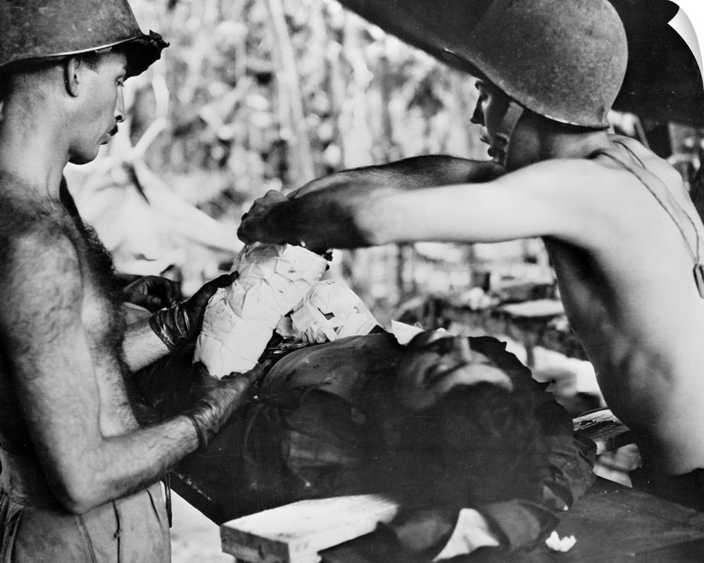 Medics operating on a wounded American soldier in New Guinea. Photograph, c1943.