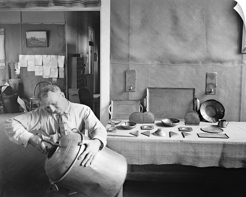 A man cutting up confiscated bootleg liquor kegs and fashioning dishes from them, during Prohibition in America, 1920s.