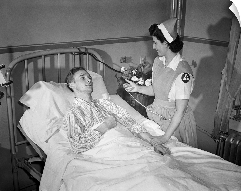 A Red Cross nurses' aide taking a patients' pulse at a hospital in Washington, D.C., 1942.