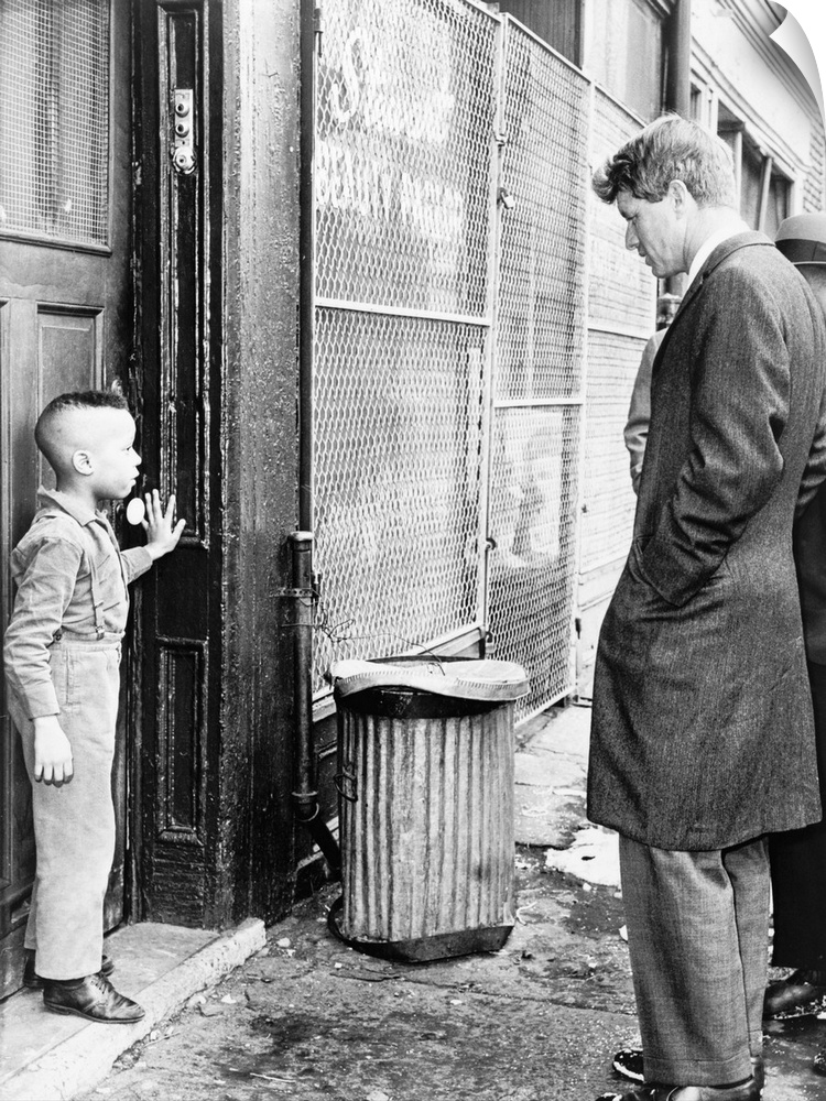 (1925-1968). American lawyer and politician. Senator Kennedy discussing school with a young boy in front of his home on Ga...